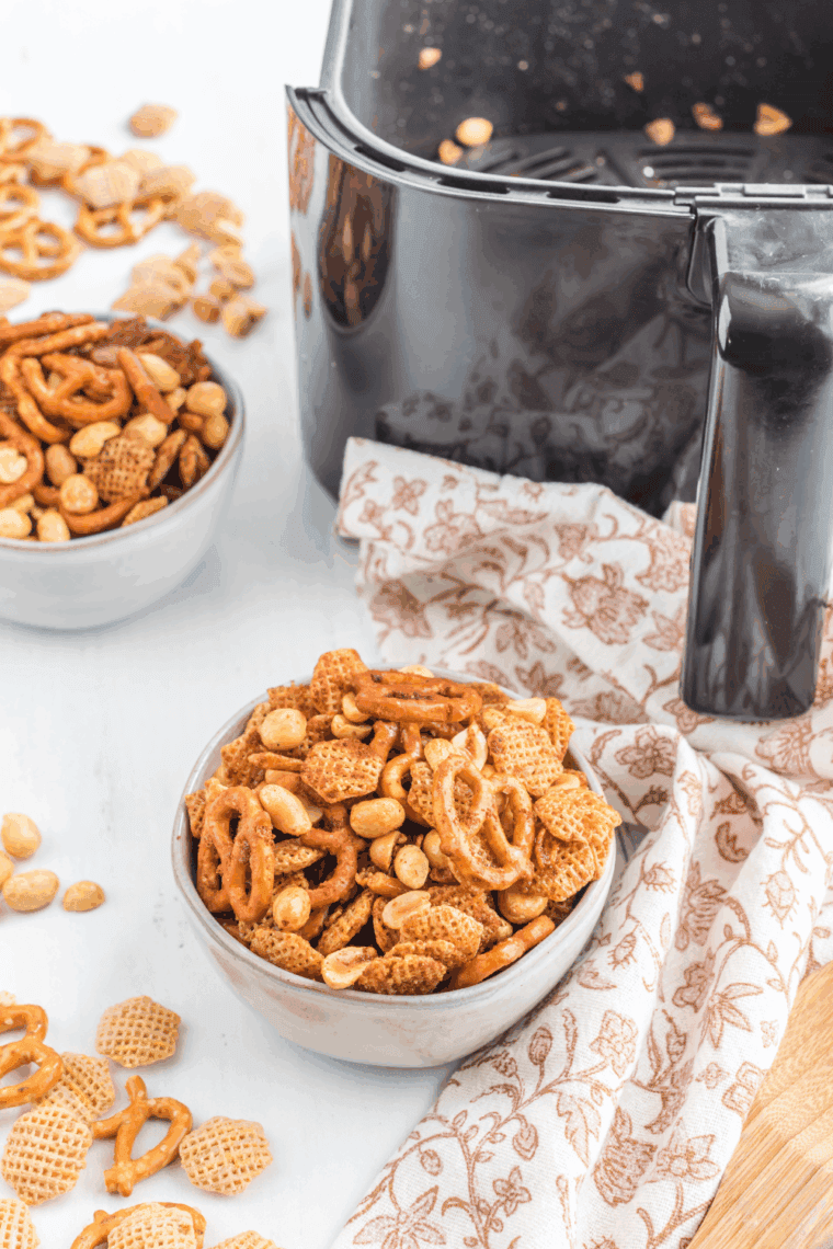 Easy Air Fryer Chex Mix in a bowl, with crispy cereal, pretzels, and nuts, seasoned and golden brown.