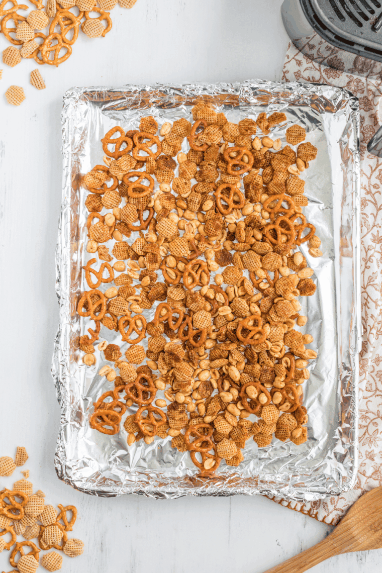 Golden-brown Air Fryer Chex Mix with cereal, pretzels, and nuts in a bowl.