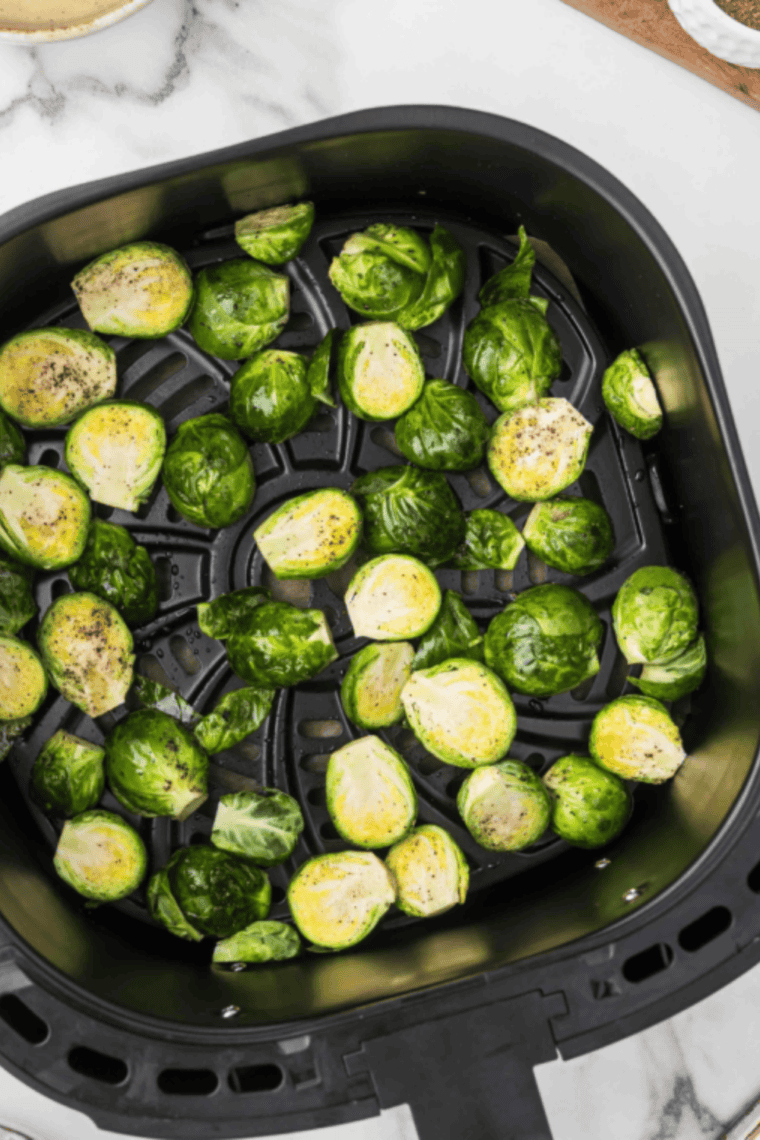 Preheat air fryer to 400°F, cook Brussels sprouts for 15-18 minutes, shaking halfway through for crispiness.