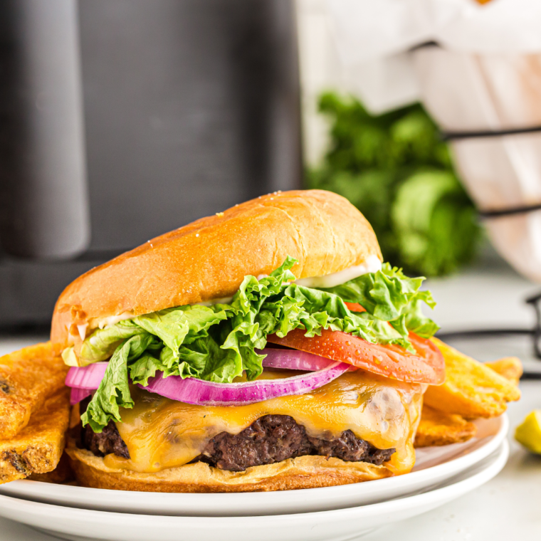 Juicy air fryer bacon cheeseburger with melted cheese and crispy bacon on a toasted bun.