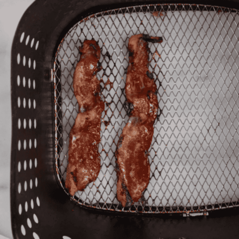 Candied bacon crisped and caramelized in the air fryer basket for a breakfast croissant.
