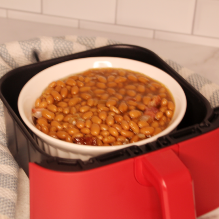 Transferring the bean mixture into the air fryer basket, ready for cooking.