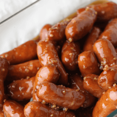 Air fryer little smokies coated in a glossy grape jelly sauce, served in a dish with toothpicks