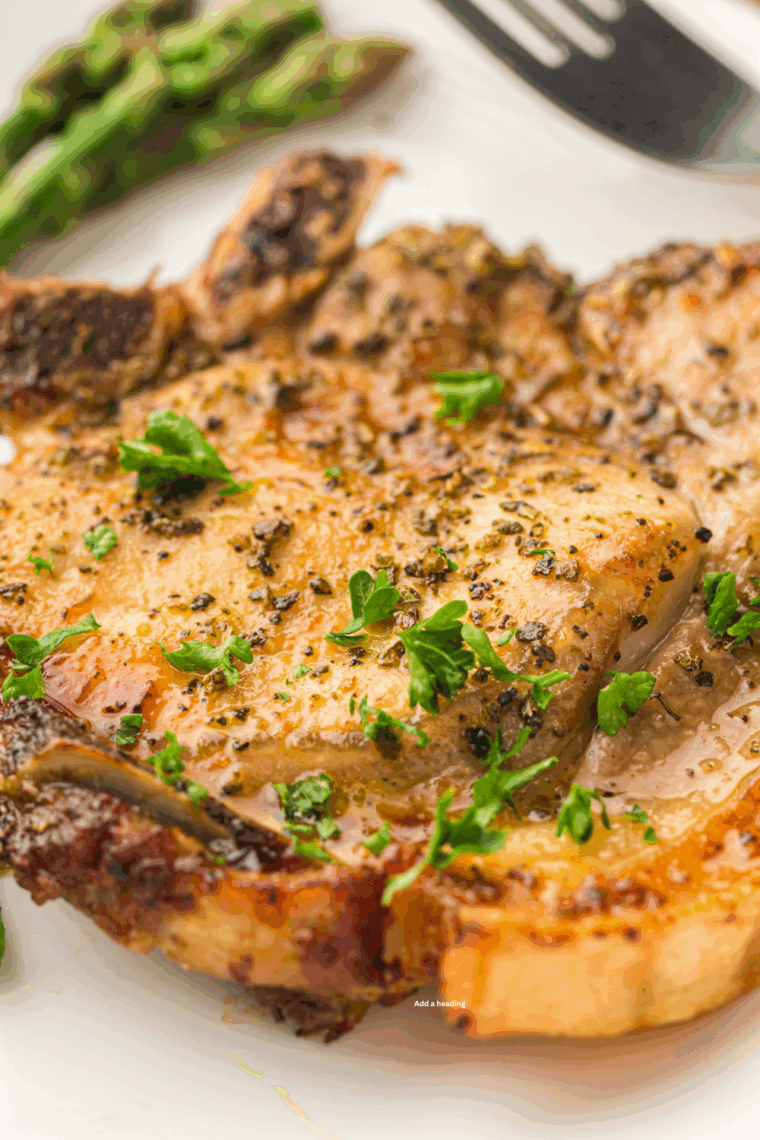 Golden brown BJ’s style pork chops served on a plate with sides