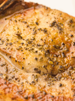 Golden brown BJ’s style pork chops served with sides on a plate