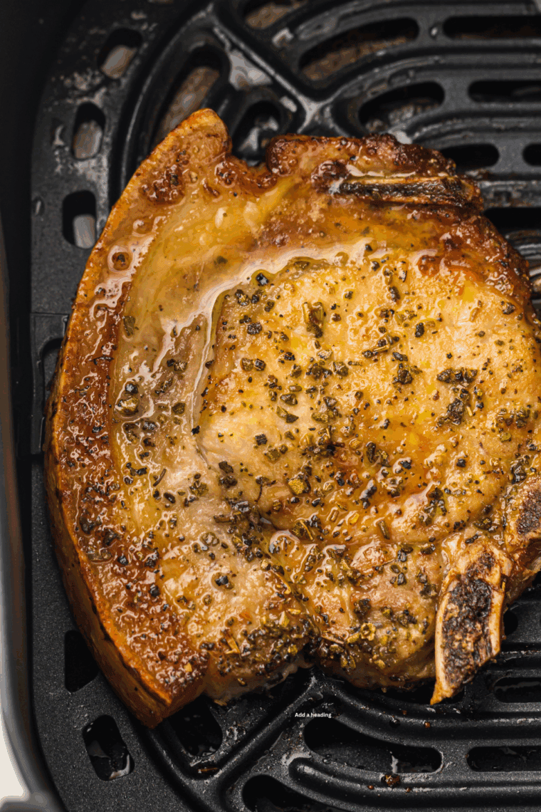 Golden brown BJ’s style pork chops served on a plate with herbs and sides