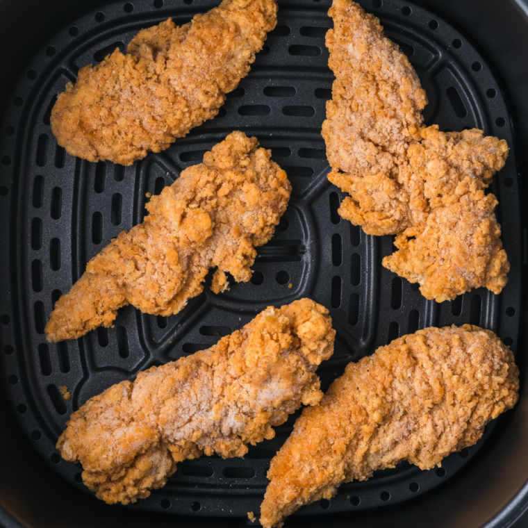 Tyson Air Fried Chicken pieces placed in a single layer in the air fryer basket, ready for cooking.