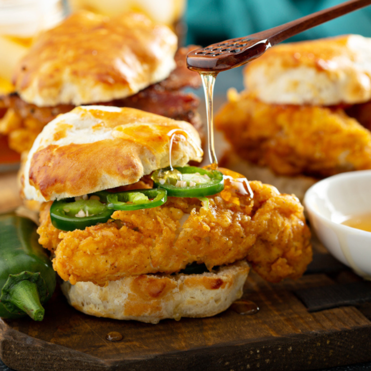 A beautifully plated serving of Tyson Air Fried Chicken, garnished with lettuce and served with dipping sauces.