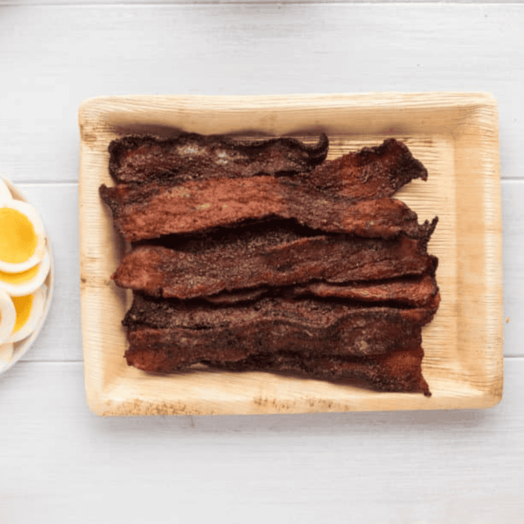 Golden, crispy Air Fryer Millionaire’s Bacon glazed with caramelized sweetness, served on a parchment-lined plate.