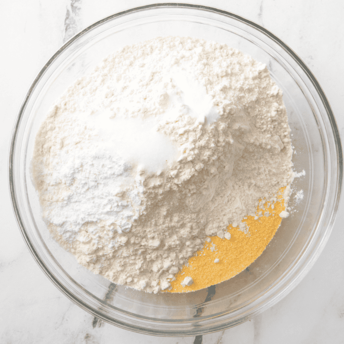 Mixing dry and wet ingredients in bowls to make cornbread batter prior to air frying.