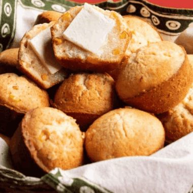 Golden, fluffy Cracker Barrel-style cornbread muffins on a plate, awaiting serving.