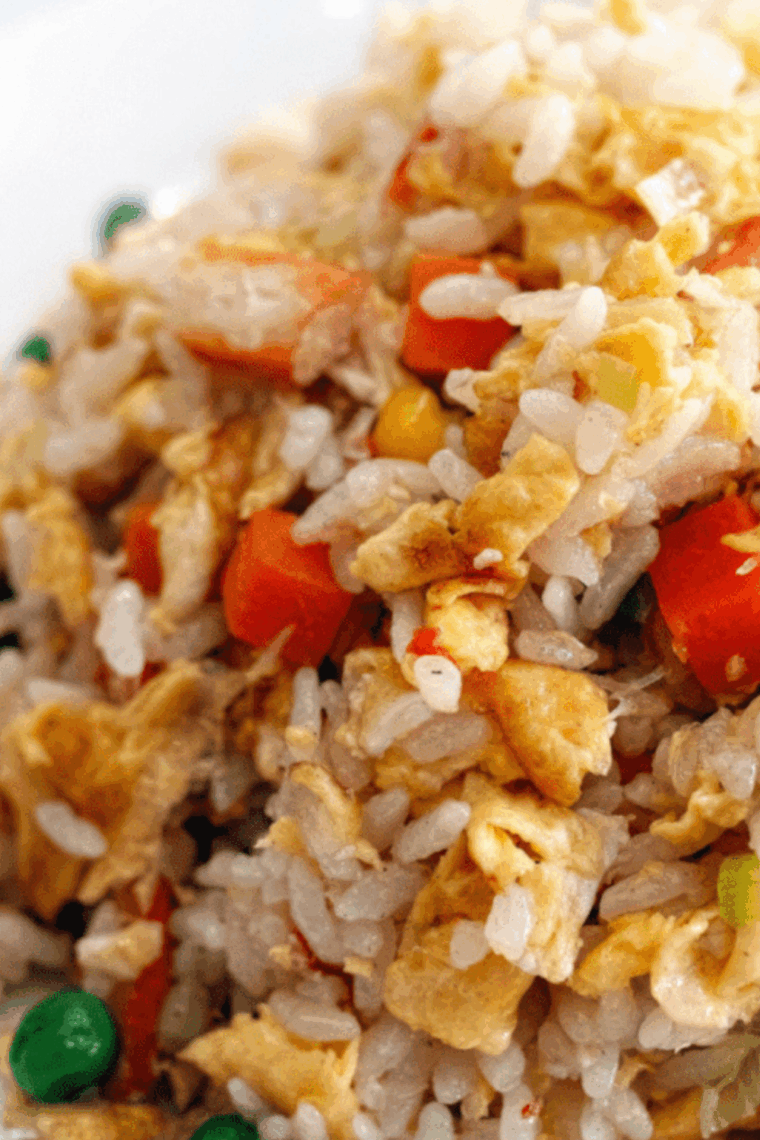 Air fryer vegetable fried rice with carrots, bell peppers, peas, and green onions in a bowl