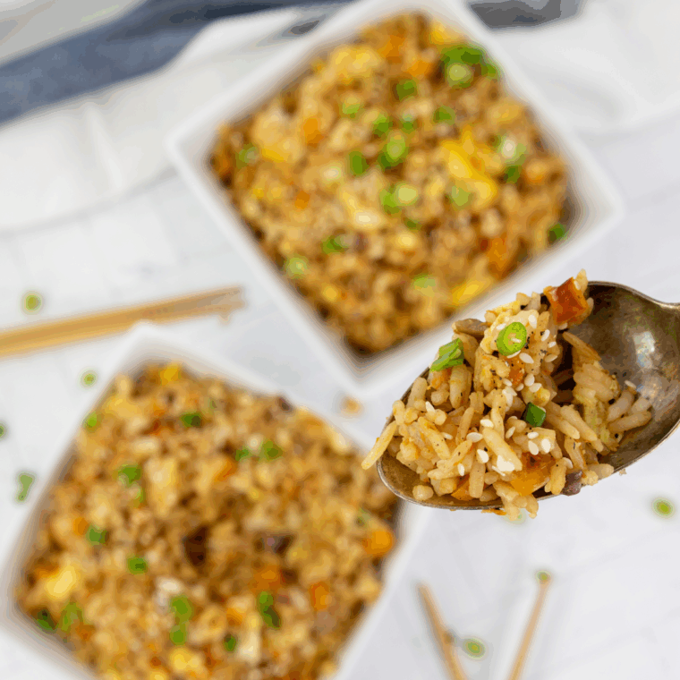 Air fryer vegetable fried rice garnished with green onions in a serving bowl