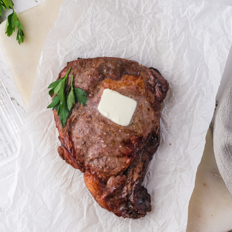 Whole Ninja Crispi steak on parchment paper beside a second steak sliced to show the pink center