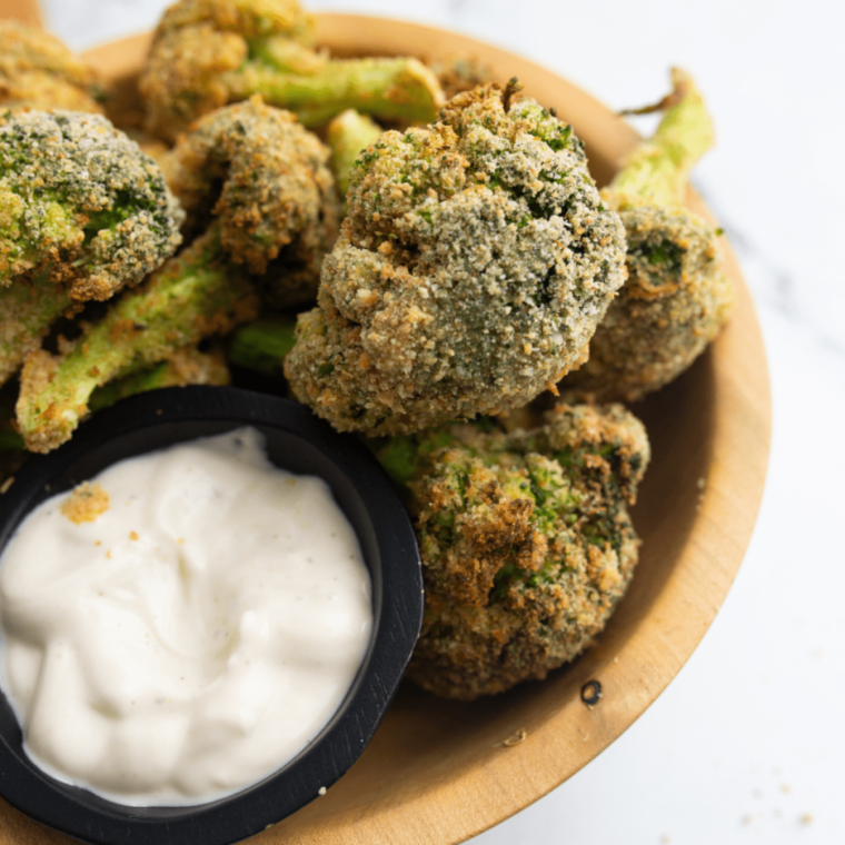 Golden brown air fryer breaded broccoli florets served in a bowl.