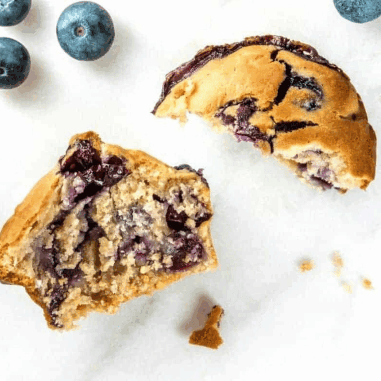 Single air fryer blueberry muffin in a ramekin with golden top and juicy blueberries, freshly baked and ready to enjoy.