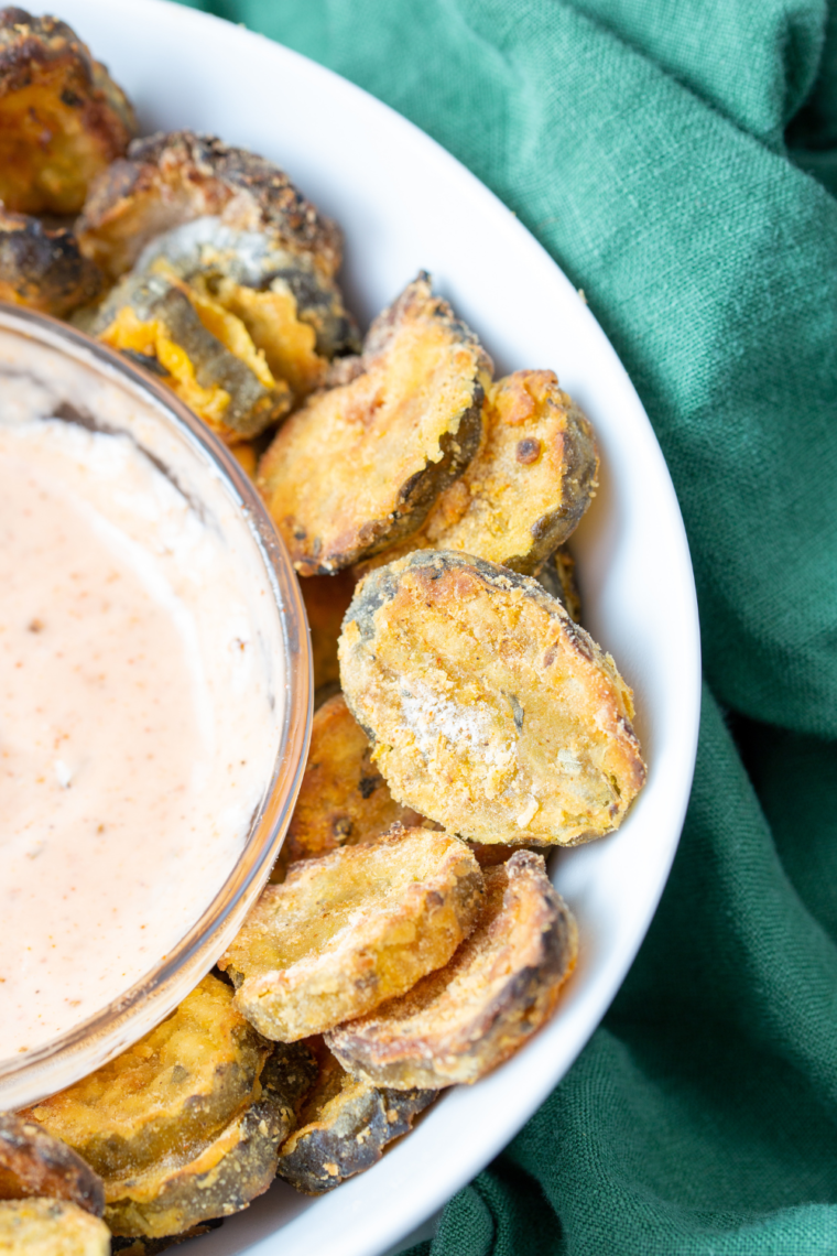 Golden-brown air-fried pickles served with a side of creamy ranch dressing.