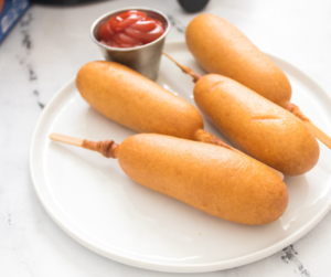 air fryer corn dogs on a plate with a side of ketchup