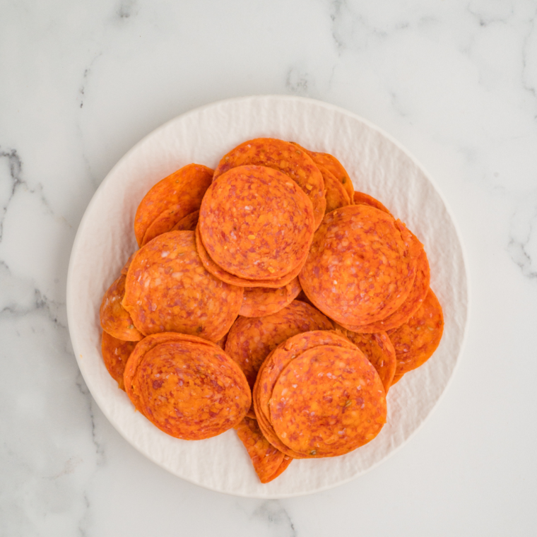 Before and after comparison of pepperoni slices in the air fryer.