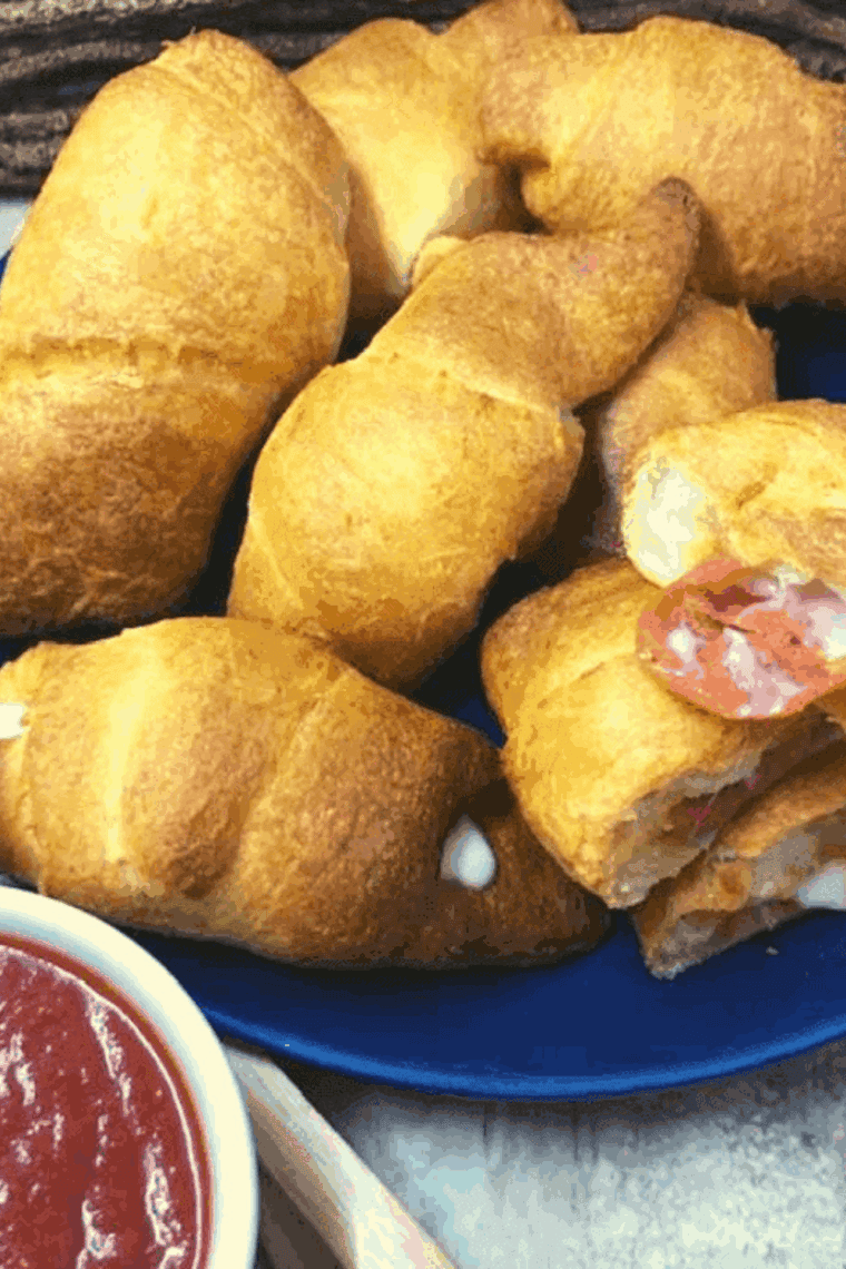 Air fried pepperoni pizza crescent rolls with golden crust, melted cheese, and a side of marinara sauce for dipping.