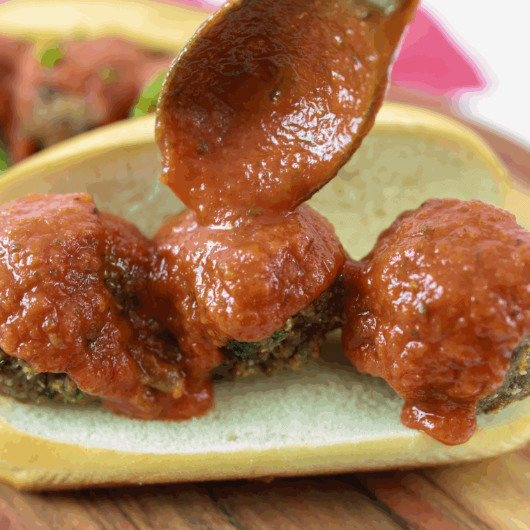 Removing cooked meatballs from the air fryer, ready to serve with dipping sauce or pasta.