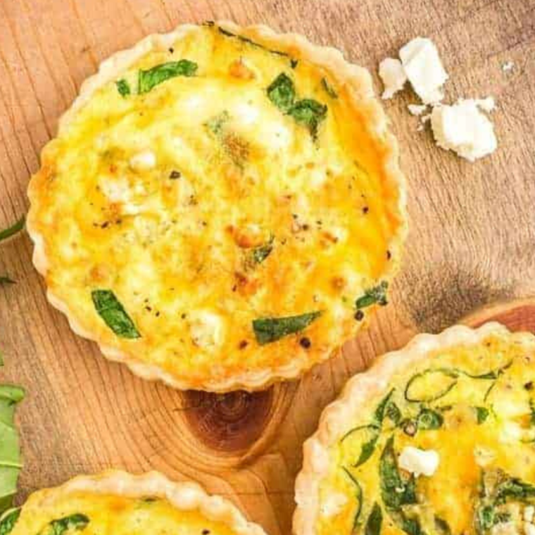 Sliced Air Fryer Spinach Feta Quiche on a cutting board