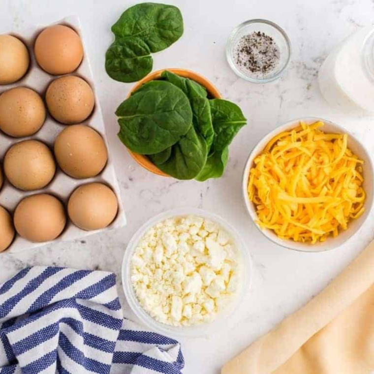 Ingredients needed for Air Fryer Spinach Feta Quiche on kitchen table.