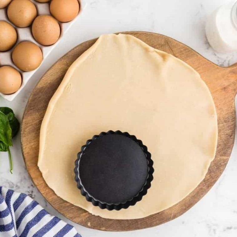 Preparing the pie crust to go into the tart pan.