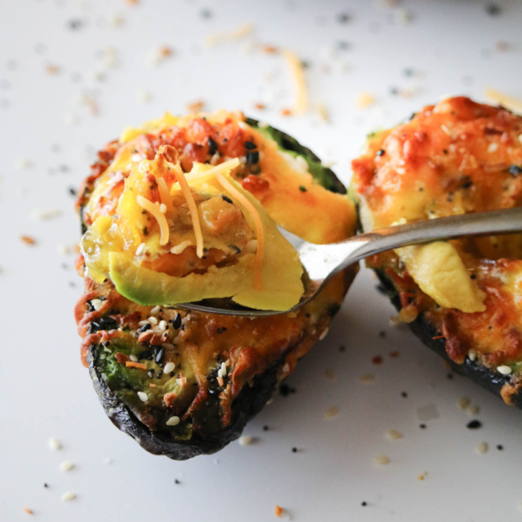 closeup: a spoon lifting up a piece of egg from an avocado egg air fryer recipe