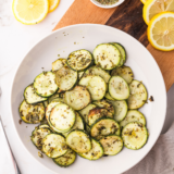 Crispy air fryer zucchini slices golden brown and lightly seasoned on a plate