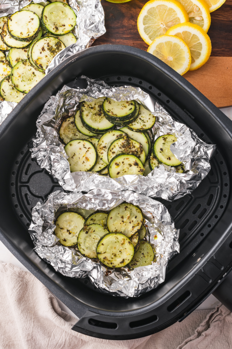 Air fryer zucchini slices cooked until crisp with browned edges and herbs