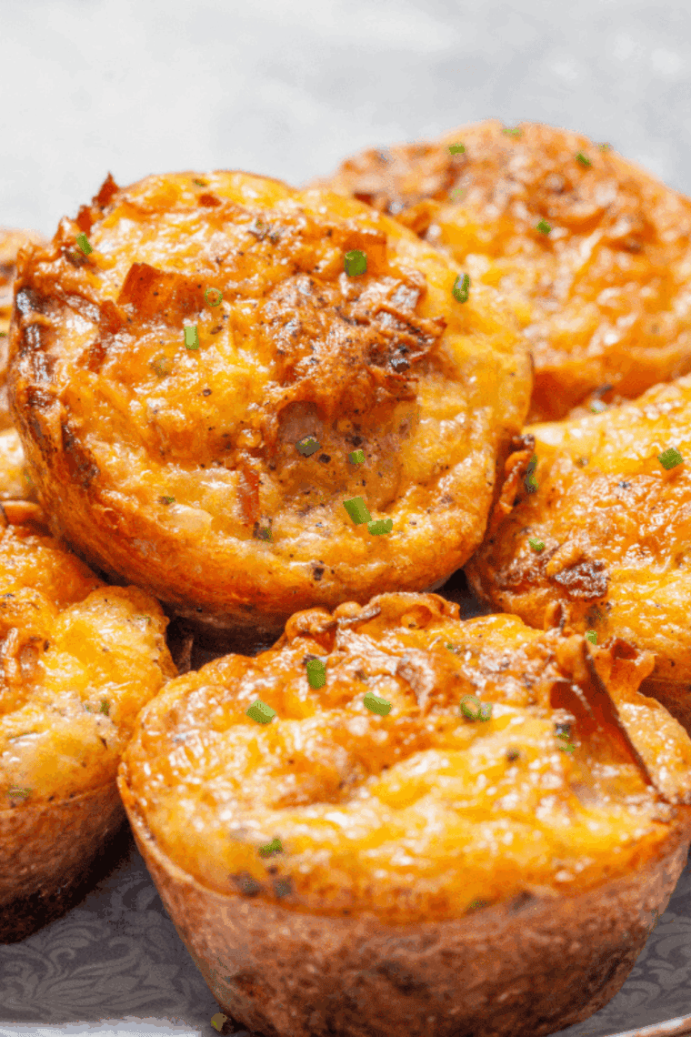 Air fryer ham and cheese muffins baked in muffin cups with fluffy eggs and melted cheddar cheese, perfect for a quick breakfast.