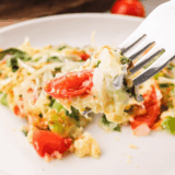 A slice of First Watch Frittata Rustica on a plate, showing eggs, cheese, and mixed vegetables.