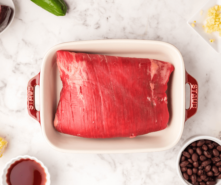 overhead: a flank steak for air fryer recipe in a staub baking dish