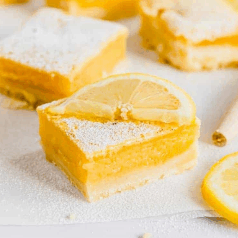 Freshly made lemon protein bars cut into squares, showcasing a bright, zesty lemon glaze.