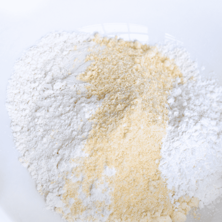 whisking light seafood batter made with flour, cornstarch, and club soda in a bowl.