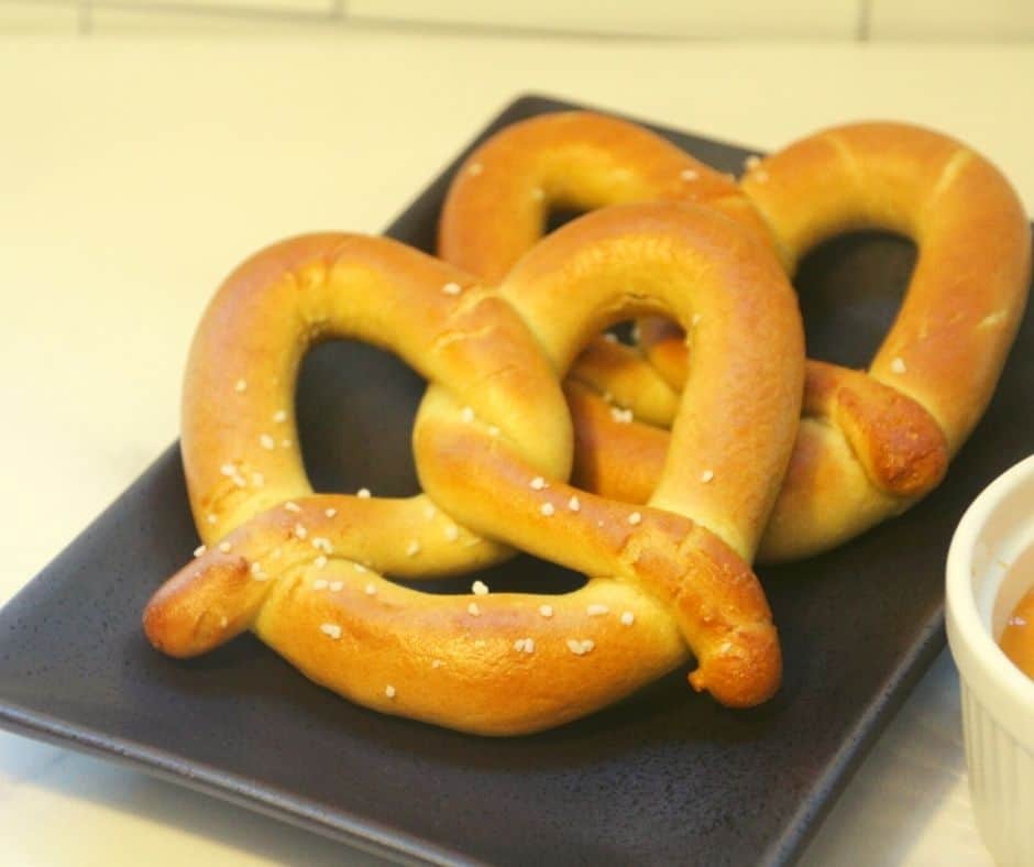 Two pretzels on a black plate. 