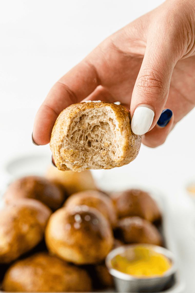 Homemade soft pretzel bites brushed with butter and salt, golden brown and served warm with cheese dip for snacking and appetizers