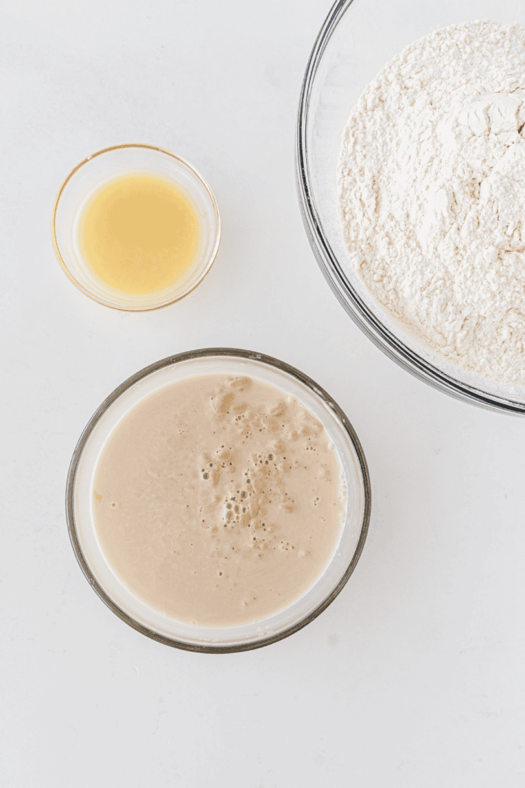 Small bowl of foamy activated yeast sitting in warm sugar water, ready for dough making.