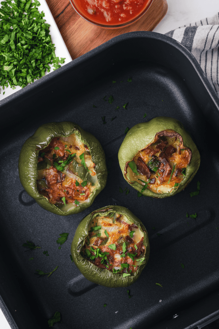 Air Fryer Breakfast Stuffed Peppers filled with eggs, cheese, and veggies, served on a plate.