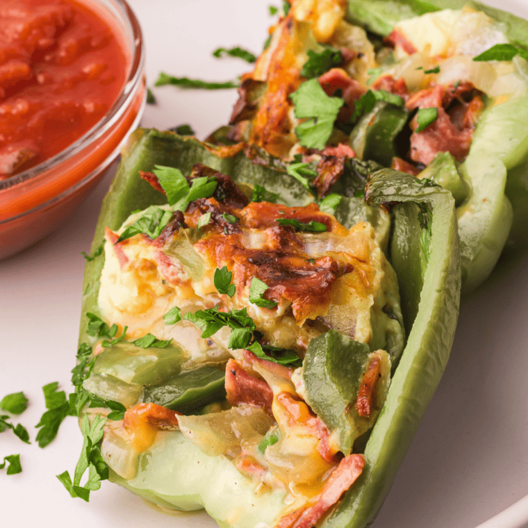 Air Fryer Breakfast Stuffed Peppers filled with eggs, cheese, and veggies, served on a plate.