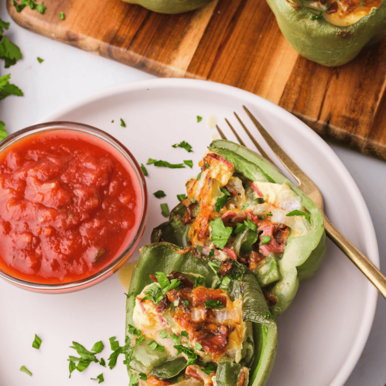 Air Fryer Breakfast Stuffed Peppers filled with eggs, cheese, and veggies, served hot on a plate.