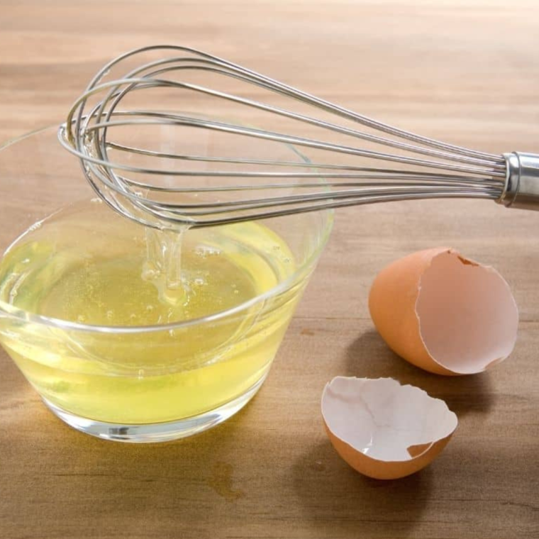Mixing bowl with egg white, vanilla, and water ready to coat almonds