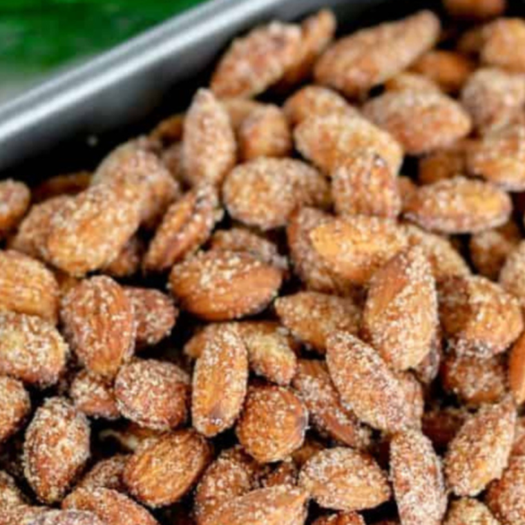 Caramelized candied almonds cooling on parchment paper after air frying