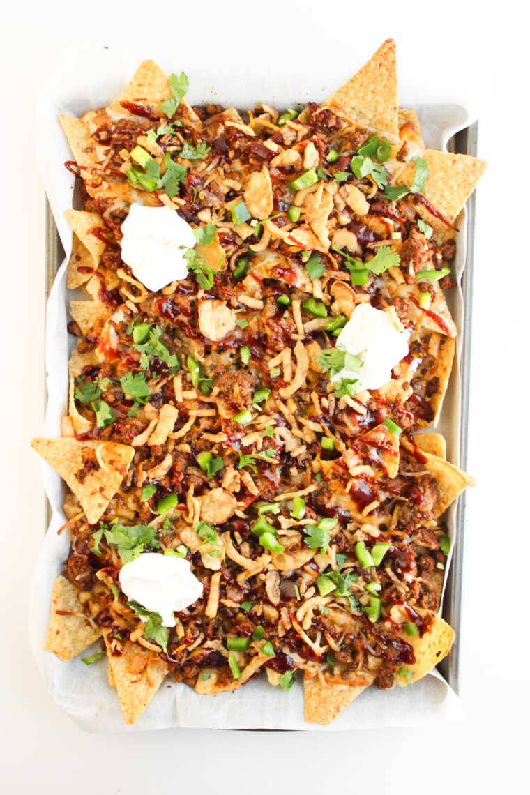 air fryer nachos bellgrande topped with sour cream tomatoes and fresh toppings after cooking
