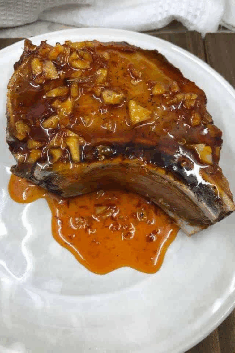 Air fryer honey garlic pork chops cooked golden brown, garnished and ready to serve.