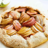 Golden air fryer pear galette with thinly sliced pears fanned inside a rustic folded crust, cooling in a tart pan