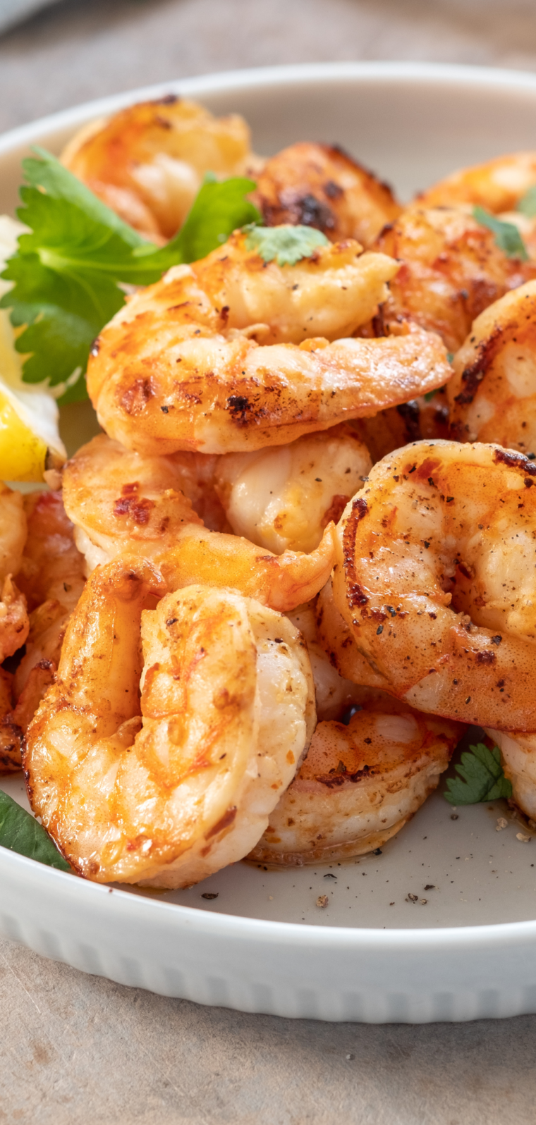 Air fried shrimp arranged on a serving platter - Crispy, golden-brown shrimp served on a platter alongside a bowl of cocktail sauce.