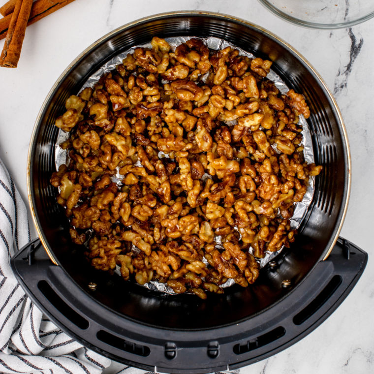 overhead: air fryer walnuts in air fryer basket before roasting