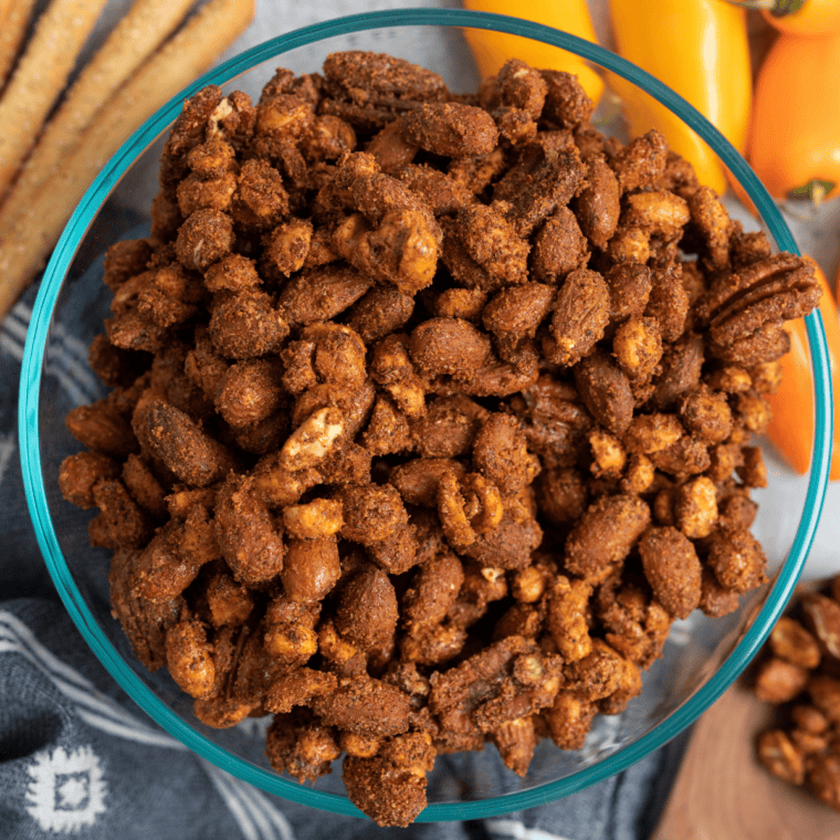 Close-up of roasted mixed nuts coated in rosemary, thyme, and cracked black pepper